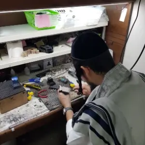 בודק את בתי התפילין עם טלית